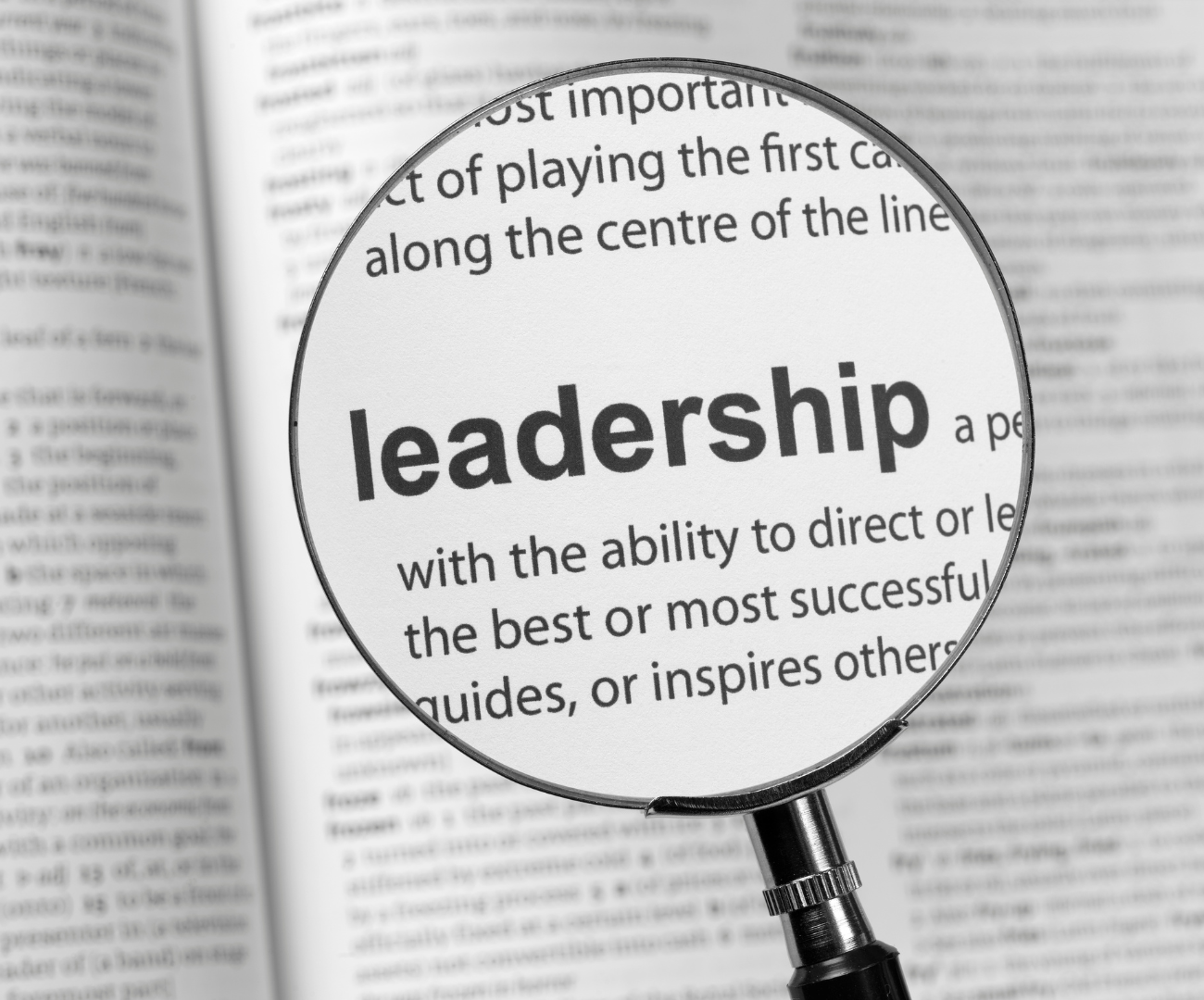 magnifying glass over the definition of leadership in a book 